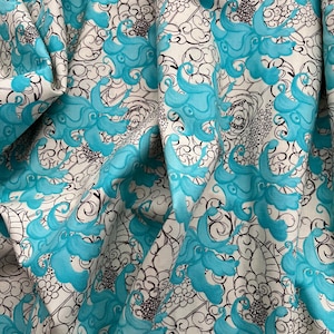 Pode incluir: Tecido branco com um padrão repetitivo de formas florais turquesa estilizadas e desenhos de linhas pretas. O tecido está drapeado, mostrando dobras e sombras, realçando a textura e profundidade do design. A estética geral é moderna e artística.