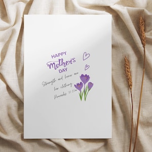 Puede incluir: Una tarjeta blanca con el texto "Happy Mother's Day" en escritura morada, acompañada de corazones morados y flores de azafrán. La tarjeta también presenta la cita "La fuerza y el honor son su vestidura. Proverbios 31:25a."