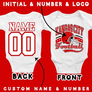 two different views of a white baby onesie with a Kansas City Football logo. The one on the left is the back view, while the one on the right is the front view. The back view shows the number 00, and the front view shows the number 00.