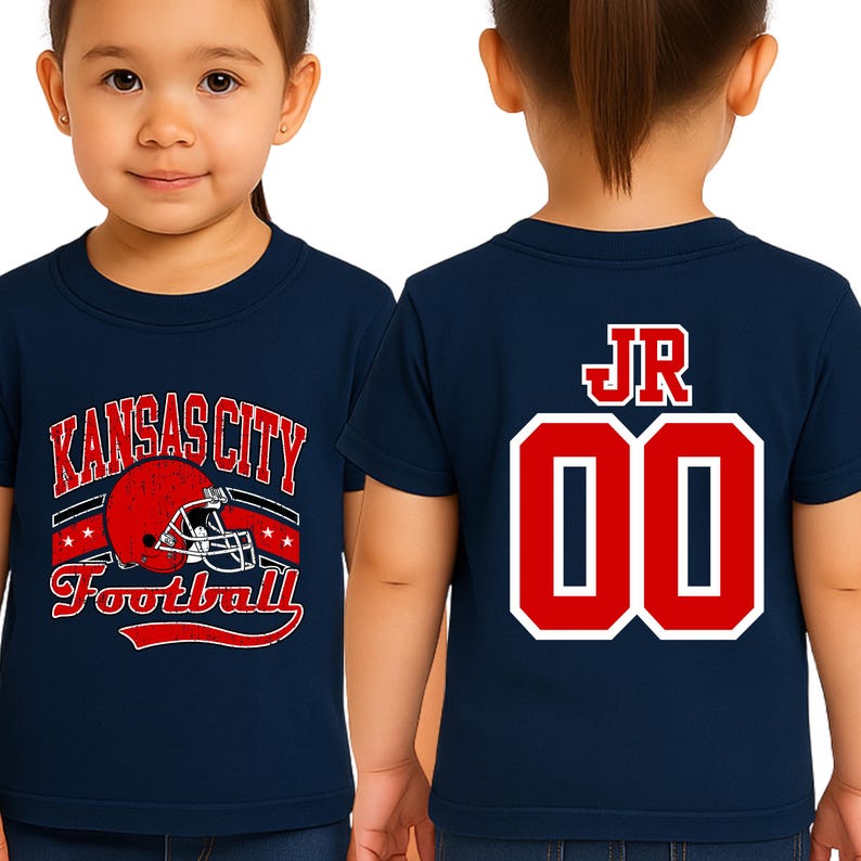 A young girl wearing a navy blue t-shirt with a football helmet and the text "KANSAS CITY FOOTBALL" printed on it.