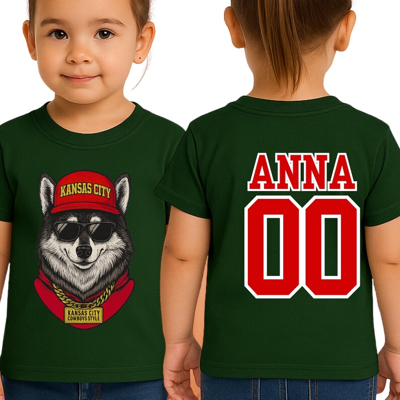 A green t-shirt with a graphic of a wolf wearing sunglasses and a red hat, along with the text "KANSAS CITY" and "KANSAS CITY COMBBOSTYLE". The back of the shirt has the name "ANNA" and the number "00" printed on it.