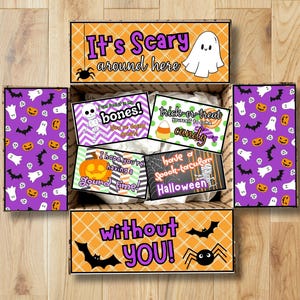 May include: Open Halloween-themed gift box with purple and orange accents. The box features text that reads "It's Scary around here" and "without YOU!" Inside are cards with Halloween phrases and graphics like ghosts, bats, and pumpkins.