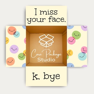 May include: An open cardboard shipping box with cream-colored flaps featuring colorful smiling face icons. The top flap reads I miss your face. The bottom flap reads k, bye. The interior base displays a white box icon and Care Package Studio text.