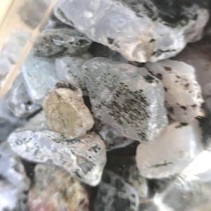 Può includere: Una collezione di pietre di varie dimensioni e forma irregolare. Le pietre presentano una gamma di colori, tra cui grigio, bianco e beige, con alcune che presentano motivi scuri e maculati. Le pietre sembrano naturali e non lucidate.