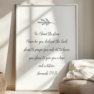 May include: A framed white print with black script. The text reads "For I know the plans I have for you. declares the Lord. plans to prosper you and not to harm you, plans to give you a hope and a future. Jeremiah 29:11." A sprig of leaves is at the top.