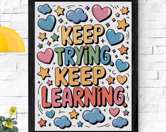 May include: A framed art print with the words "KEEP TRYING KEEP LEARNING" in colorful bubble letters. The design includes cartoon hearts, stars, and clouds in shades of blue, pink, and orange against a white background.
