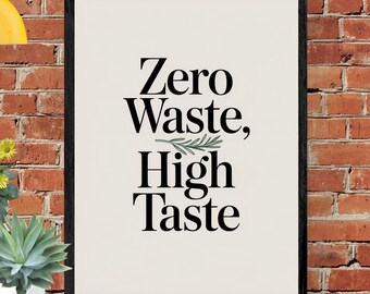 May include: A framed print with the words "Zero Waste, High Taste" in black font on an off-white background. The print is in a black frame and set against a red brick wall. A small succulent plant in a white pot is visible.