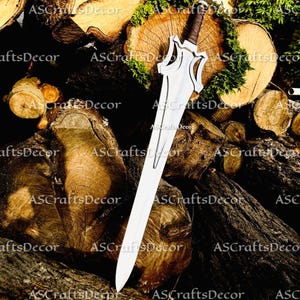 Può includere: Una spada d'argento con un'elsa decorativa e un'impugnatura marrone poggia su un mucchio di tronchi di legno. La lama della spada è lunga e dritta, e l'elsa ha un design unico e stilizzato. I tronchi sono di varie dimensioni e forme, alcuni ricoperti di muschio.