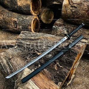 May include: A katana sword with a patterned steel blade and a black wrapped handle, accompanied by a matching black textured scabbard. The blade features a visible wavy temper line, and the hilt has a circular guard and a diamond-patterned grip.