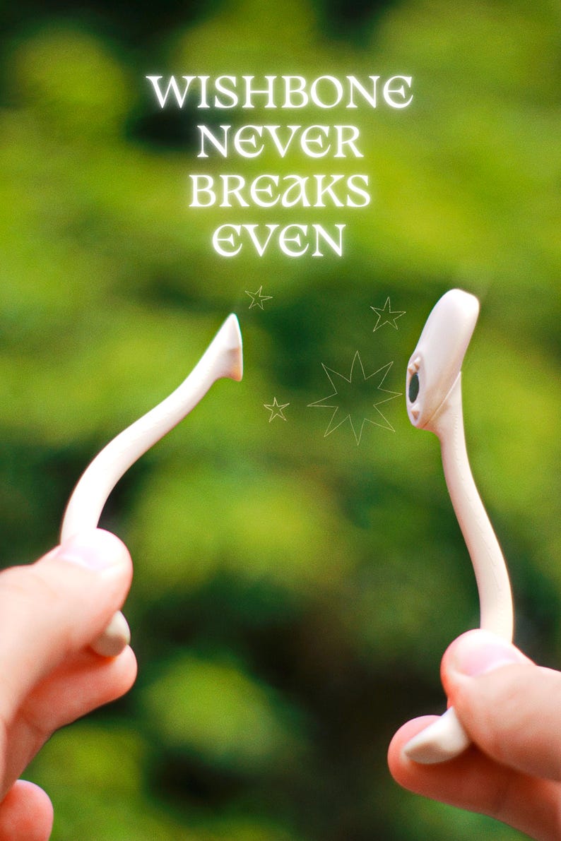 May include: A close-up of a wishbone held between two hands, with the text "WISHBONE NEVER BREAKS EVEN" in white. The background is a blurred green. The wishbone is white and has a curved shape.