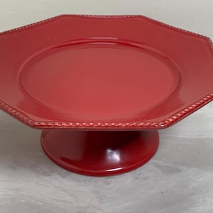 May include: A set of three ceramic mugs with a speckled, cream-colored glaze. Each mug features a different hand-painted floral design in shades of blue, green, and yellow. The mugs have a simple, rounded shape and a comfortable handle.