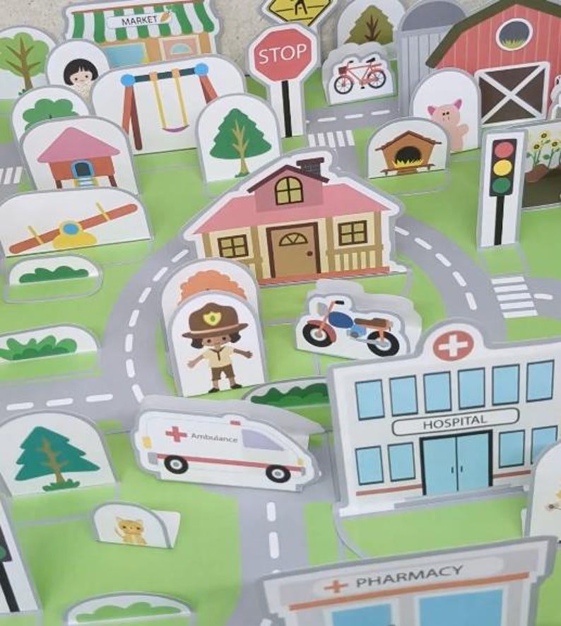 Op de afbeelding: Een kleurrijke, ge&iuml;llustreerde speelset met een stadsbeeld met gebouwen, wegen en voertuigen. Inclusief een ziekenhuis, apotheek, markt en een stopbord. De set heeft een groen- en grijskleurenschema.