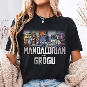 Pu&ograve; includere: T-shirt nera con grafica della serie Star Wars, "The Mandalorian and Grogu". Il design presenta vari personaggi della serie, con il testo del titolo in argento. La maglietta &egrave; a girocollo.