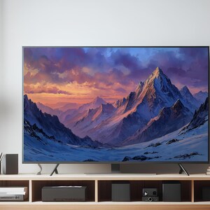 Peut inclure: Un grand téléviseur à écran plat affiche une peinture de paysage de montagne. L'œuvre présente des sommets enneigés sous un ciel dramatique aux teintes violettes, orangées et bleues. Le téléviseur est posé sur un meuble de rangement en bois clair.