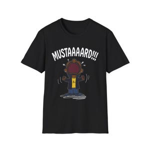 May include: Black t-shirt featuring a cartoon character with an open mouth and the word "MUSTAAAARD!!!" in white. The character is wearing a yellow shirt and a black jacket. The design is a playful and humorous graphic.