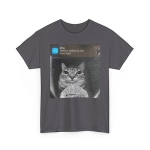 Puede incluir: Camiseta gris oscuro con una imagen en blanco y negro de un gato. La imagen incluye una notificación de Ring que dice "Hay movimiento en tu puerta principal."