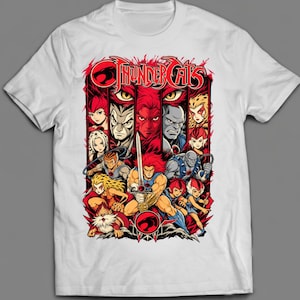 May include: A white short-sleeved t-shirt featuring a vibrant graphic print of the Thundercats characters. The design includes the red Thundercats logo, the text "THUNDERCATS," and a detailed illustration of the ensemble cast in red and black tones.