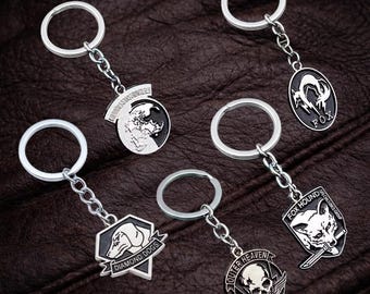 Metal Gear Solid Outer Heaven-sleutelhanger, gamersleutelhangercadeau, videogamesleutelhanger, animespelhanger, autosleutelhanger voor mannen vrouwen