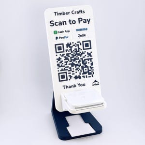 May include: A white vertical payment sign with a dark blue QR code, featuring the text Timber Crafts, Scan to Pay, and logos for Cash App, Venmo, PayPal, and Zelle. The sign includes a small white shelf and sits on a dark blue base.
