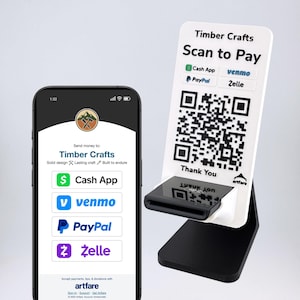 May include: A smartphone displays payment options for Timber Crafts, including Cash App, Venmo, PayPal, and Zelle. A white and black stand with a QR code for scanning to pay is also shown. The stand says "Thank You".