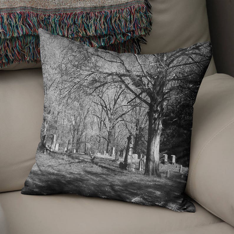 Peut inclure: Photographie en noir et blanc d'un cimeti&egrave;re avec des arbres nus et des pierres tombales. La photo est prise d'un angle bas, regardant les arbres.