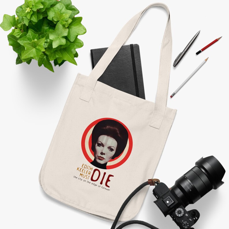 May include: A white canvas tote bag with a red circle and a woman's face in the center. The text "Edith Keeler Must Die" is below the circle. The city on the edge of forever is written below the text.