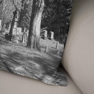 Peut inclure: Une photographie en noir et blanc d'un cimeti&egrave;re avec un grand arbre au centre. La photo est prise d'un angle bas, regardant l'arbre. L'arbre est entour&eacute; de pierres tombales et d'autres arbres. La photo est l&eacute;g&egrave;rement floue, ce qui lui donne un aspect vintage.