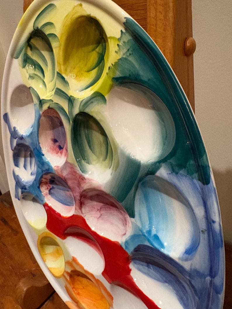 May include: Oval ceramic serving platter with multiple oval compartments. The platter is hand-painted with a colorful design featuring shades of yellow, green, blue, red, and white. The design is abstract and artistic, with brushstrokes visible.