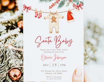 May include: A Christmas-themed baby shower invitation with the words "Santa Baby" in red script. The invitation features a clothesline with baby clothes and Santa hat illustrations. The invitation includes the date, time, and location.