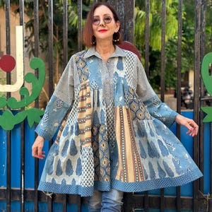 Light blue cotton shirt with a trapeze style silhouette. A tiered design, with pockets from soft, hand printed fabric in pale indigo hues