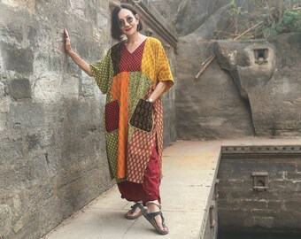 Colorful kaftan dress with an asymmetrical patchwork design. Side slits, a V neckline and pockets. Loose fitting style with a wide sleeve!