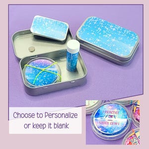 May include: A set of silver metal tins with blue and white starburst designs. One tin is open, revealing a round item secured with a green band, a small tube, and a rectangular lid. The text "Choose to Personalize or keep it blank" is visible.