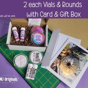 May include: A gift set with two vials and rounds, a card, and a gift box. The vials and rounds have colorful designs and the text "Cats". The card features a nature image. The text on the vials reads "Amazing, Loving, Strong, Happy, Selfless, Graceful."