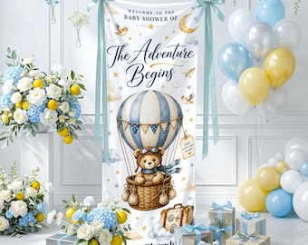 Può includere: Un banner per baby shower con un design a mongolfiera con un orsacchiotto in un cestino. Lo striscione recita "Benvenuti al Baby Shower di The Adventure Begins" in elegante scrittura. Palloncini, fiori e scatole regalo decorano la scena.