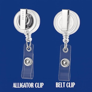 May include: Two clear retractable badge holders with silver detailing. One has an alligator clip, and the other has a belt clip. The text "ALLIGATOR CLIP" and "BELT CLIP" are printed below the holders.