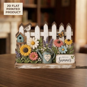Könnte beinhalten: Ein flaches 2D-Deko-Schild mit einem weißen Lattenzaun, einem blauen Vogelhaus, einem kleinen Vogel, einem Schmetterling, verschiedenen bunten Blumen, einer blauen Gießkanne mit einem Herzaufdruck Bloom & Grow und einem Schild mit HELLO SUMMER.