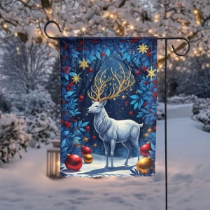 May include: A garden flag featuring a white deer with golden antlers adorned with ornaments. The deer stands in a snowy scene surrounded by red berries, blue leaves, and golden snowflakes. The background is a winter wonderland with snow-covered trees.