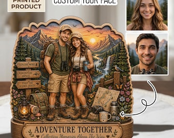 Può includere: Un prodotto in legno stampato piatto 2D raffigurante una coppia in abbigliamento da trekking, ambientato in un paesaggio montano con una cascata e un tramonto. La base recita "ADVENTURE TOGETHER." Include il testo "CUSTOM YOUR FACE."