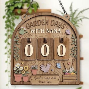 May include: Wooden garden sign with the text "GARDEN DAYS WITH NANA" and the numbers "000". The sign features a decorative design with flowers, butterflies, gardening tools, and the text "Garden Days with Nana Rose". It hangs from a chain.