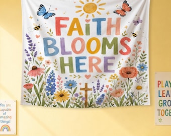 Può includere: Un arazzo da parete bianco con il testo multicolore "FAITH BLOOMS HERE" centrato sotto un sole giallo. Il design include illustrazioni di farfalle, api e vari fiori di campo colorati che circondano una croce di legno marrone.