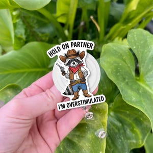 Funny Cowboy Raccoon Badge Reel – “Hold On Partner I’m Overstimulated” – Cute Neurodivergent Gift, Occupational Therapist Humor Clip, Nurse