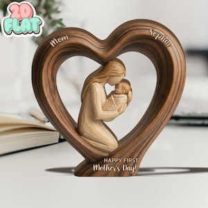 May include: A wooden heart-shaped sculpture featuring a mother cradling a baby. The sculpture has the words "Mom" and "Sophia" carved on the top, and "Happy First Mother's Day!" at the bottom. The sculpture is made of a dark brown wood.