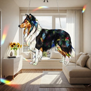 May include: A decorative, stained-glass-style dog silhouette, suspended from the ceiling. The dog features a black, white, and brown coat with colorful geometric accents. The artwork is hanging in a well-lit room with a neutral color palette.
