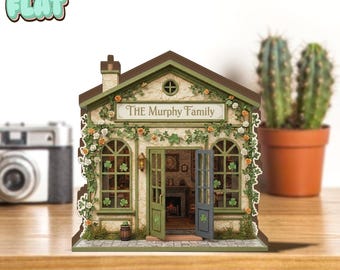 Peut inclure: Une maquette de maison miniature avec l'inscription "THE Murphy Family" au-dessus de la porte. La maison a des bordures vertes, un toit marron et est ornée de fleurs et de trèfles. Les portes sont ouvertes, révélant un intérieur détaillé.