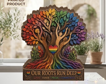 May include: A wooden, layered art piece depicting a tree with rainbow-colored leaves and roots. The tree's trunk features figures with raised arms, and a heart with a rainbow flag. The base reads "Our Roots Run Deep."