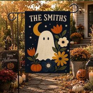 May include: A rectangular garden flag featuring a dark blue background with the text THE SMITHS at the top. The design includes a white ghost, a yellow crescent moon, white stars, orange and yellow flowers, and an orange pumpkin.