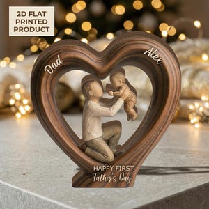 Puede incluir: Escultura de madera en forma de corazón con una figura de padre e hijo en su interior. La escultura tiene las palabras "Dad" y "Alex" en la parte superior y "Happy First Father's Day" en la inferior. Producto impreso en 2D.