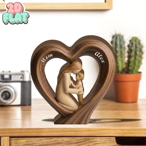 May include: A wooden heart-shaped sculpture with a mother and child figure inside. The sculpture is brown with the words "Mom" and "Alex" inscribed. The sculpture is on a wooden surface.