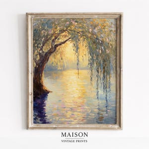 May include: A framed vintage print of a serene waterscape. A weeping willow tree with yellow-green leaves hangs over a shimmering lake reflecting the sunlight. The print is framed with a light-colored, ornate border. The text "MAISON VINTAGE PRINTS" is at the bottom.