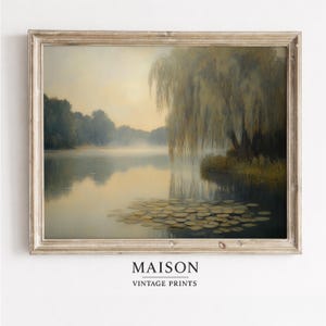 May include: A framed vintage print of a serene lake scene. The artwork features a weeping willow tree on the right, with lily pads in the foreground. The water reflects the sky and trees. The print is labeled "MAISON VINTAGE PRINTS".